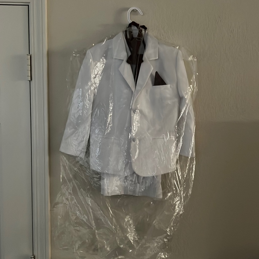 A boys tuxedo all white with burgundy tie and vest